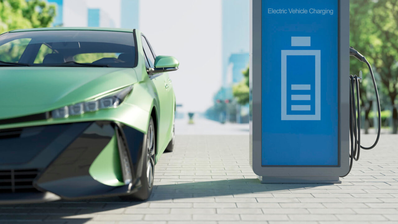 Green electric car at charging point